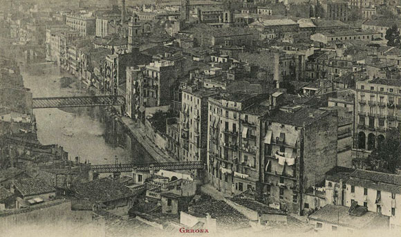 Vista del barri del Mercadal des del campanar de la Catedral. Travessen l'Onyar els ponts de Sant Agust&iacute;, de les Peixateries Velles i al fons, el pont de Pedra. En primer terme a la dreta, la pla&ccedil;a de la Independ&egrave;ncia i al fons, el campanar de l'esgl&eacute;sia de les Bernardes, el de Santa Susanna i les naus i la xemeneia de la f&agrave;brica Gr&ograve;ber. 1919-1925