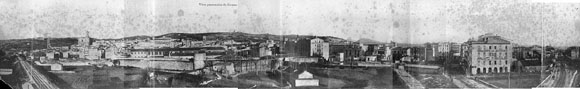 Vista panor&agrave;mica del barri del Mercadal des del baluard del Governador. En primer terme a l'esquerra, un tram de la muralla del Mercadal compr&egrave;s entre el baluard de la Santa Creu i i el portal d'&Aacute;lvarez, a l'altura de la f&agrave;brica Gr&ograve;ber. A la dreta, la ronda Ferran Puig i les vies que menen a l'antiga estaci&oacute; de tren. Al fons, d'esquerra a dreta, la muntanya de Montju&iuml;c amb el castell, el campanar de l'esgl&eacute;sia de Sant Feliu, la Catedral, el convent de Sant Dom&egrave;nec, la torre de les Aig&uuml;es i la pla&ccedil;a Marqu&egrave;s de Camps amb el Banc d'Espanya. 1908