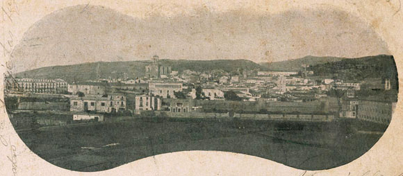 Vista de la ciutat des de l'eixample. En primer terme a la dreta, el convent de les Adoratrius. En segon terme, el tram de la muralla del Mercadal compr&egrave;s entre el baluard de Santa Clara i la pla&ccedil;a Calvet i Rubalcaba. Al centre, l'Hospital de Santa Caterina. 1896-1905