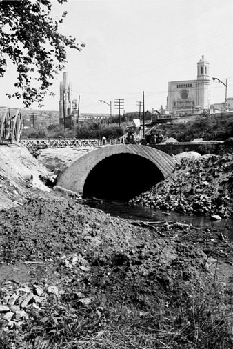Obres de canalitzaci&oacute; del riu G&uuml;ell a l'altura de la Devesa, amb el Pont del Rellotge, la via del tren, la Catedral i l'esgl&eacute;sia de Sant Feliu. 1963