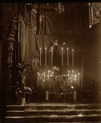 Vista parcial d'un altar ornamentat per la celebraci&oacute; de la Setmana Santa a l'esgl&eacute;sia de Sant Feliu. A la dreta de la imatge s'observen dues dones resant. 1923