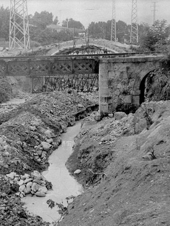Obres de desmuntatge del pont del Dimoni sobre el riu G&uuml;ell. En primer terme, el pont del carrilet d'Olot. Juliol 1968