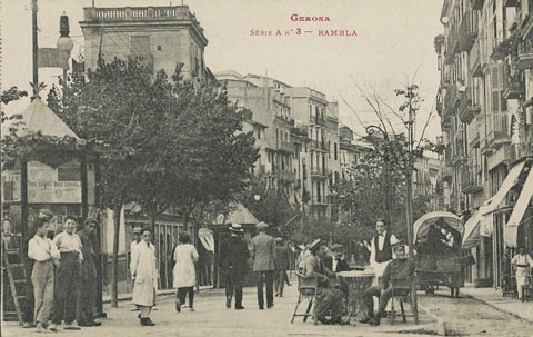Vista de la la part alta de la Rambla de la Llibertat amb uns homes asseguts a la terrassa del Caf&egrave; Expr&eacute;s. A l'esquerra s'observa el quiosc. A la dreta hi circula una carruatge. 1920