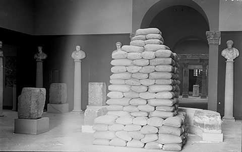  Sacs de terra protegint l�escultura de la deesa del carrer Parad&iacute;s a la sala d�Inscripcions commemoratives del Museu d'Arqueologia de catalunya (1937-1938)