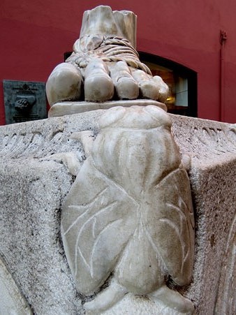 Detall del mon&ograve;lit dedicat a la llegenda de la petjada de Sant Narc&iacute;s a la cantonada del carrer de les Mosques amb el del Pou Rod&oacute;