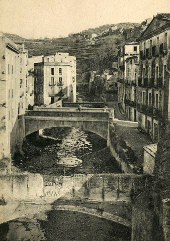 Vista des d'un punt elevat del riu Galligants al seu pas pel barri de Sant Pere. En primer terme, un aq&uuml;educte, en segon terme, el pont del carrer de la Barca i darrera seu, el pont del carrer del Llop. 1905-1911