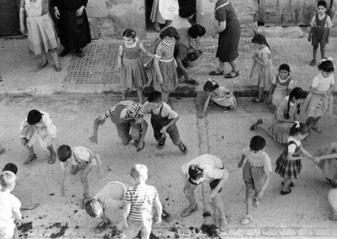 Mainada recollint 'bateig'. Ca. 1955
