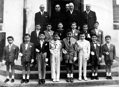 Retrat d'un grup de nens de les Escoles d'Ensenyament Primari de Foment de Cultura vestits de Primera Comuni&oacute;. Els acompanya, entre d'altres, moss&egrave;n Joaquim Batlle. Ca. 1960