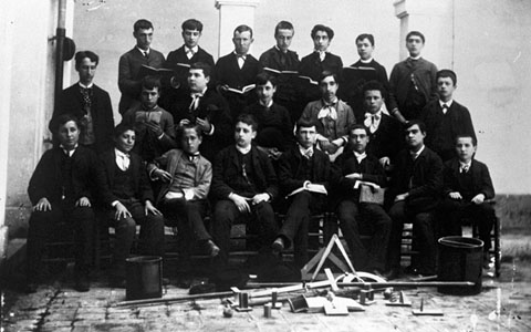 Retrat d'un grup d'alumnes de l'Institut de Segon Ensenyament al claustre de l'Institut Vell. A terra s'observa una mostra del material pedag&ograve;gic emprat a les aules. 1900-1910