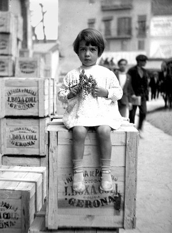 Retrat de Rosa Boxa sobre una de les caixes de pasta de la f&agrave;brica Boxa, a la pla&ccedil;a Marqu&egrave;s de Camps. 1931