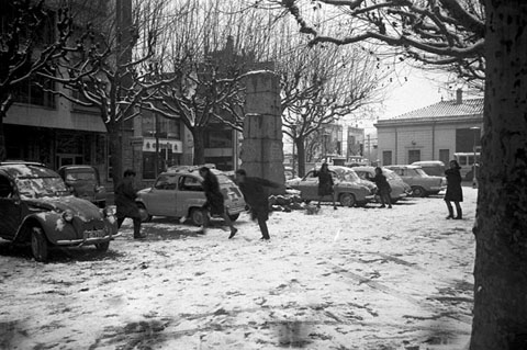Nens jugant amb la neu a la pla&ccedil;a Poeta Marquina, davant l'estaci&oacute; de tren. Al centre, el monument als caiguts durant la Guerra Civil. 1967