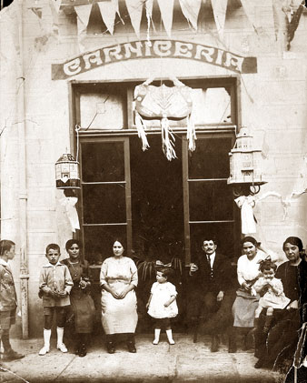 Fa&ccedil;ana d'una carnisseria a la pla&ccedil;a Poeta Marquina. Davant d'establiment membres de la fam&iacute;lia Met Caracas i el propietari, Joan Verderi. 1915-1918