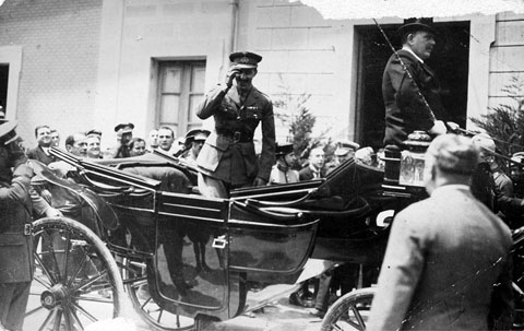 Visita oficial del rei Alfons XIII a la ciutat de Girona. El monarca saludant des d'un cotxe de cavalls la gent aplegada a la pla&ccedil;a del Carril, davant l'estaci&oacute; de tren. 28 de maig de 1930