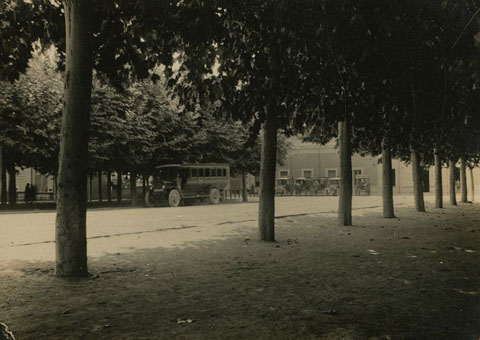 Autob&uacute;s aparcat a la pla&ccedil;a del Carril. Al fons, l'estaci&oacute; del tren. 1935-1940