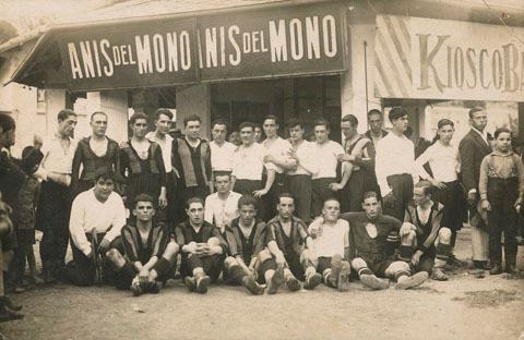 El quiosc d'en Monta&ntilde;a al camp de futbol de Vista Alegre de Girona. Al davant, dos equips de futbol. S'identifica a dalt: Sumsi I, Colls, Marqu&egrave;s, Pere Vila, Bosch, Gibert, Gadea, Salvi, F&agrave;brega, Teixidor, Casas, Ismael, Alvalat, Gauchia, Fern&agrave;ndez, Rabas, Juanito i Monta&ntilde;a. A baix: Amadeu Oliva, Sumsi II, Quintana, Balan&ccedil;&agrave;, Pag&egrave;s, Dalmau, Puig i Norat. 1921-1930