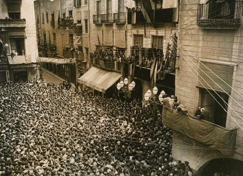 Francesc Maci&agrave; al balc&oacute; de l'Ajuntament amb l'alcalde Miquel Santal&oacute; adre&ccedil;ant-se als gironins aplegats a la pla&ccedil;a del Vi. Als baixos de l'ajuntament el Caf&egrave; d'en Vila i la seu de l'Esbart Giron&iacute;