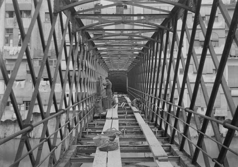 Obres al pont de les Peixateries Velles. S'observen els obrers treballant en la substituci&oacute; de la fusta del paviment, en el marc de les obres de reparaci&oacute; dutes a terme per la casa constructora Torras de Barcelona. 1923