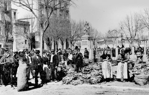 Mercat de verdures i hortalisses instal&middot;lat a la pla&ccedil;a de la Independ&egrave;ncia, just al costat de l'escultura als Defensors de Girona el 1808 i 1809. 1910