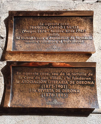 Plaques commemoratives de l'estada de Francesc Camb&oacute; i de les tert&uacute;lies de la 'Cova de can Vi&ntilde;as' a la fa&ccedil;ana de la casa n&uacute;mero 2 del carrer dels Abeuradors