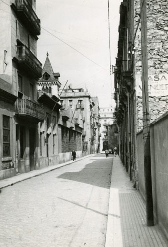 Carrer d'Anselm Clav&eacute; despr&eacute;s de la col&middot;locaci&oacute; de llambordes. En primer terme a l'esquerra, la fa&ccedil;ana de l'Escola de Mestres i al fons, el xalet Juand&oacute;. 1952