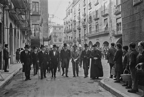 Fires de Sant Narc&iacute;s. Les autoritats entrant al carrer Ciutadans des de la pla&ccedil;a del Vi. D'esquerra a dreta, el delegat provincial d'Hisenda, Joaquim Casanovas Ogu&eacute;s, el president de l'Audi&egrave;ncia Provincial, Jos&eacute; Mar�a Mesa Fern&aacute;ndez, l'alcalde, Josep Bonet Cuff&iacute;, el governador civil, Ram&oacute;n Mu&ntilde;oz Gonz&aacute;lez, el governador militar, Emerio Feliu Oliver, el president de la Diputaci&oacute;, Pere Ordis Llach i un sacerdot. 1968