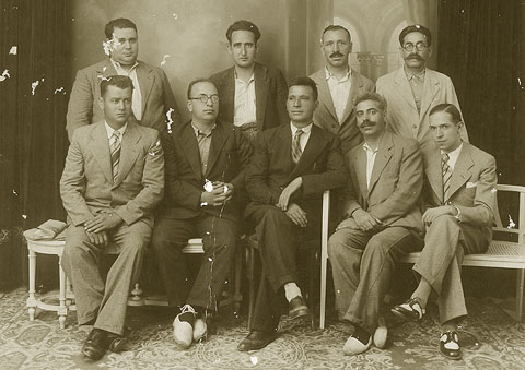 Retrat de grup dels membres de la Federaci&oacute; de Flaquers de les Terres Gironines. A dalt, Taularia, Llonch, Centenys. A baix: Teixidor, Arilas i Joan Dalmau Pla, amb fleca al carrer Hortes. 1930
