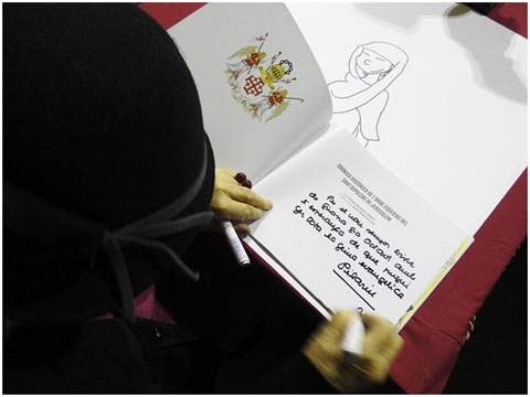 Pilarin Bay&eacute;s signant un exemplar de 'Cr&ograve;nica Hist&ograve;rica de l'Orde Equestre del Sant Sepulcre de Jerusalem', de Ramon Muntada amb il&middot;lustracions d'ella mateixa