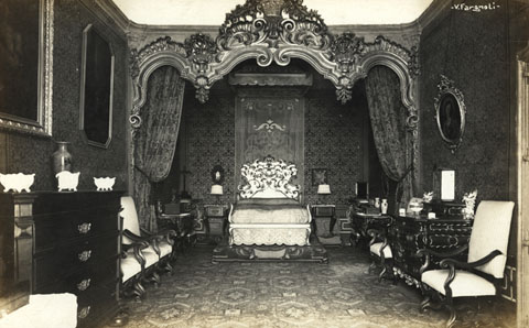 Dormitori reial de la casa Carles. Del mobiliari i la decoraci&oacute;, en destaquen el llit amb cap&ccedil;alera, les calaixeres, les cadires, les peces de cer&agrave;mica i els quadres. En aquest dormitori hi van dormir D. Juan Bosco i hi va reposar Alfons XIII. 1910-1915