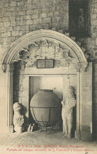 Detall de l'estructura d'una porta del convent de Sant Francesc conservada en una galeria del claustre del monestir de Sant Pere de Galligants, seu del Museu d'Arqueologia. Sota la porta, un recipient cer&agrave;mic d'or&iacute;gen rom&agrave; conegut amb el nom de dolium