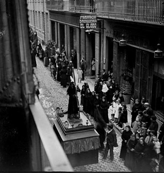 Celebraci&oacute; del Divendres Sant. Vista de la process&oacute; al seu pas pel carrer Nou des del balc&oacute; de la casa Batlle. Al fons, la farm&agrave;cia i la drogueria El Globo