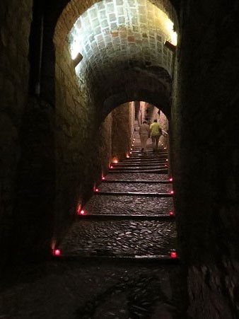 Carrer de Sant Lloren&ccedil;, il&middot;luminat amb espelmes que indiquen el cam&iacute; per visitar la pe&ccedil;a Aig&uuml;es projectada al micv&eacute;