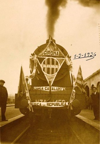 Tren engalanat a l'andana d'una estaci&oacute;, possiblement la de Girona. En els cartells es llegeix: Girona. 16 febrer. Visca Catalunya. Visca la Rep&uacute;blica