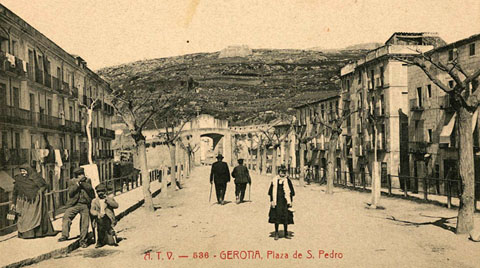 Vista de la pla&ccedil;a de Sant Pere amb el portal de Fran&ccedil;a al fons. Darrera seu la muntanya de Montju&iuml;c, on destaquen al centre la Torre de Sant Joan i a la dreta el castell hom&ograve;nim. 1900-1909