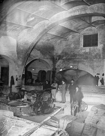 Retrat d'un grup d'homes dins una de les naus de la f&agrave;brica de paper l'Aurora. 1900-1925