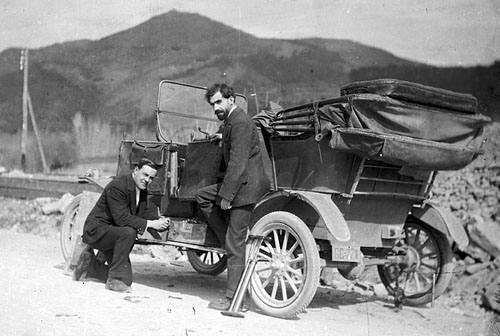 Miquel de Palol Felip acompanyat d'un altre home, canviant la roda d'un cotxe al cam&iacute; de Bescan&oacute;, durant la construcci&oacute; de les centrals d'Electroqu&iacute;mica Berenguer. 1912-1939