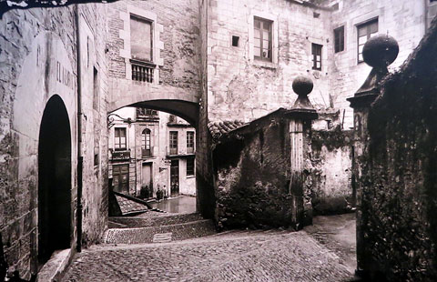 Palau dels Agullana i Pujada de Sant Dom&egrave;nec. Al fons, l'Associaci&oacute; Obrera La Amistat i un grup de nois a l'entrada de l'antic Registre de la Propietat. Girona. 1915-1925