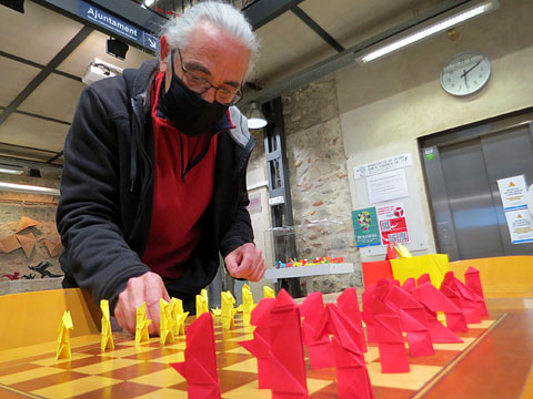 Jordi Pericot muntant al tauler les peces d'un joc d'escacs fet amb la t&egrave;cnica de l'Origami