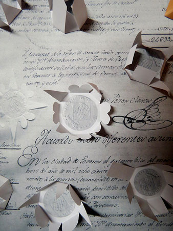 Al centre: document giron&iacute; del segle XIX amb el segell que l'autentifica embolcallat de paper retallat i plegat (r&egrave;plica). A l'entorn, treballs de Pericot que hi s&oacute;n inspirats