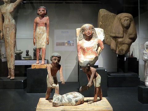 En primer terme, maqueta funer&agrave;ria d'uns carnissers a punt d'esquarterar un cap de bestiar. Fusta. Dinasties XI-XII (2134-1783 aC)
