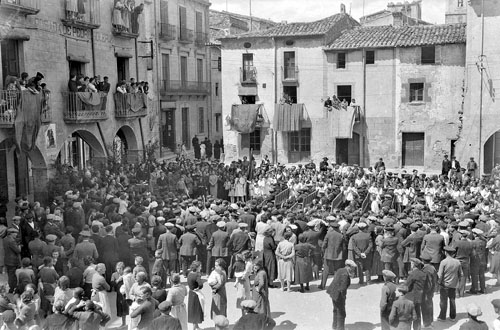 Celebraci&oacute; de la festa d'Homenatge a la Vellesa a Amer. Ancians i assistents asseguts en bancs enmig de la pla&ccedil;a del poble escoltant els parlaments de les autoritats. 1935
