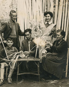 La fam&iacute;lia Olivas, cistellers de Banyoles, al pati de casa seva al carrer Major de Banyoles, fent palmes per al Diumenge de Rams. Podem veure de dalt a baix i d'esquerra a dreta: Francesc Olivas, Dolors Olivas, Xavier Olivas, Joan Olivas i Caterina Coll. 1945
